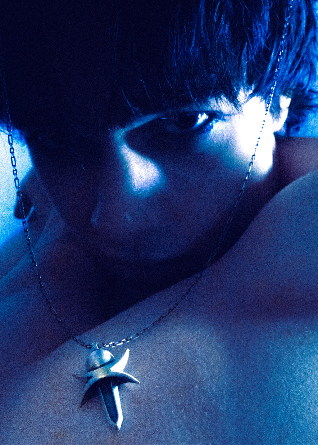 Close-up of a person wearing a silver necklace with a star pendant.